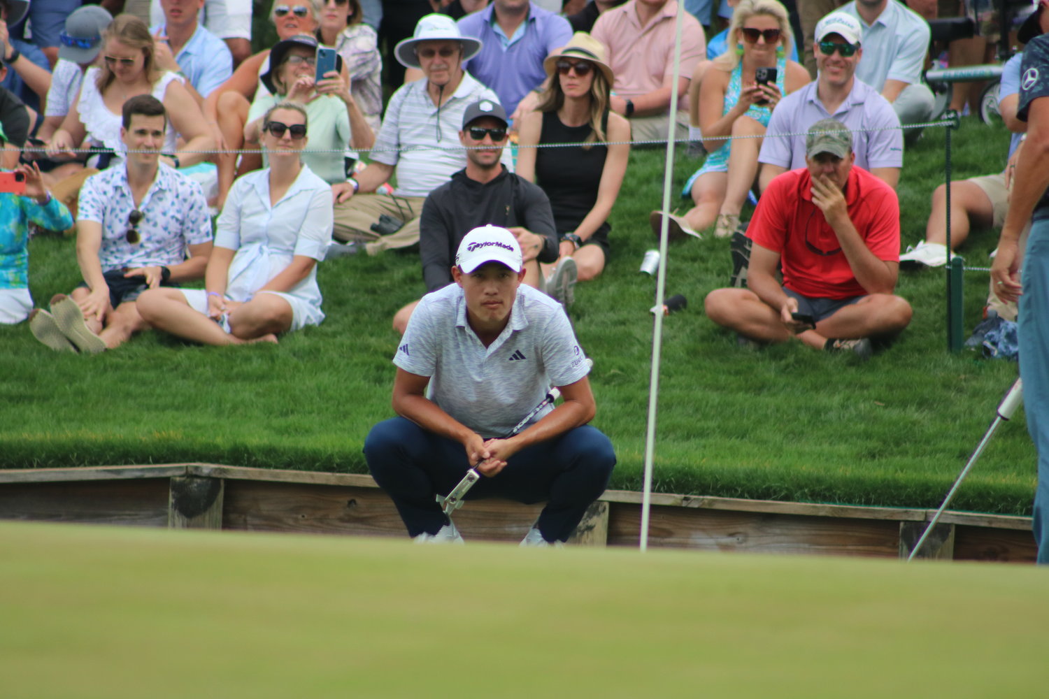 Collin Morikawa contemplates a potential putt as fans watch on during second round action at the 2023 Players Championship.